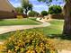 Lush community park with a walking path, green lawns, flowering shrubs, and mature trees at 6030 W Topeka Dr, Glendale, AZ 85308