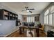 Home office featuring built-in shelving, hardwood floors, natural light from the windows, and contemporary artwork at 6030 W Topeka Dr, Glendale, AZ 85308