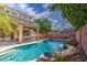 Backyard oasis featuring a sparkling pool with rock waterfall and mature trees offering ample shade at 6030 W Topeka Dr, Glendale, AZ 85308