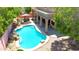 Aerial view of a refreshing pool with stone accents, lounge area, and covered patio, surrounded by lush greenery at 6030 W Topeka Dr, Glendale, AZ 85308