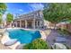 Inviting pool area with a rock waterfall, set amidst a lush yard with covered patio and desert landscaping at 6030 W Topeka Dr, Glendale, AZ 85308