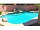 Close-up shot of the in-ground pool featuring a rock waterfall feature and cool, refreshing water at 6030 W Topeka Dr, Glendale, AZ 85308