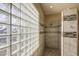 Shower with glass block window and tile walls with decorative accents at 6030 W Topeka Dr, Glendale, AZ 85308