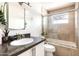 Bathroom featuring a granite countertop and a glass-enclosed tub/shower combo at 6522 E 2Nd St, Scottsdale, AZ 85251