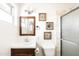 Bathroom with a rustic vanity and a shower with glass doors and tile surround at 6522 E 2Nd St, Scottsdale, AZ 85251