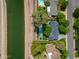 Aerial view showing a pool, patio, manicured lawn, and roofline of a home next to a walking path and waterway at 6837 E Lafayette Blvd, Scottsdale, AZ 85251