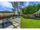 Expansive backyard view with a pool, patio dining set, mature trees, and well-manicured lawn at 6837 E Lafayette Blvd, Scottsdale, AZ 85251