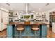 Kitchen island featuring wood countertop, breakfast bar, and views of the lush backyard at 6837 E Lafayette Blvd, Scottsdale, AZ 85251