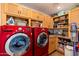 Well-lit laundry room featuring bright red washer and dryer and ample cabinet space at 6837 E Lafayette Blvd, Scottsdale, AZ 85251
