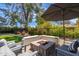 Cozy outdoor patio with a fire pit, comfortable seating, and landscaped surroundings for relaxation at 6837 E Lafayette Blvd, Scottsdale, AZ 85251