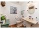 Cozy powder room with a pedestal sink, rustic decor, and modern fixtures at 6837 E Lafayette Blvd, Scottsdale, AZ 85251
