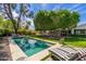 Lush backyard featuring a pool and lounge chairs surrounded by meticulously maintained landscaping at 6837 E Lafayette Blvd, Scottsdale, AZ 85251