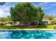 Inviting backyard featuring a sparkling swimming pool surrounded by lush landscaping and large shade trees at 6837 E Lafayette Blvd, Scottsdale, AZ 85251