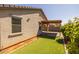 Lovely backyard featuring a wooden pergola and synthetic grass at 7343 W Hughes Dr, Phoenix, AZ 85043