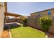 Inviting backyard featuring green synthetic grass, a wooden beam pergola, and block wall at 7343 W Hughes Dr, Phoenix, AZ 85043