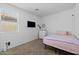 Comfortable bedroom with carpet, a tv, dresser, large window, and a bed with a pink comforter at 7343 W Hughes Dr, Phoenix, AZ 85043