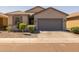 Charming home exterior featuring a gray garage door, desert landscaping, and a paved driveway at 7343 W Hughes Dr, Phoenix, AZ 85043