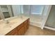 Bathroom with a soaking tub, shower, and double vanity with wood cabinetry at 7425 W Crown King Rd, Phoenix, AZ 85043