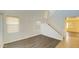 Bright living room featuring wood-look flooring, a staircase, and large windows at 7425 W Crown King Rd, Phoenix, AZ 85043