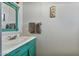 Bathroom with a teal vanity, mirror, sink, towel rack, and decorative pictures on the wall at 870 S La Paz Rd, Maricopa, AZ 85139