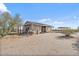 Exterior view of home featuring desert landscape, metal roof, and rustic features at 870 S La Paz Rd, Maricopa, AZ 85139