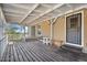 Covered porch with wooden floors, white railings, and a secure metal door at 870 S La Paz Rd, Maricopa, AZ 85139
