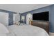 Bedroom with white bedding, blue walls, a TV, and access to the bathroom and closet at 928 W Natal Ave, Mesa, AZ 85210