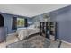 Comfortable bedroom with an area rug, dark blue walls, modern shelving, and a window at 928 W Natal Ave, Mesa, AZ 85210