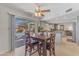 Open-concept kitchen and dining area with a wooden table, four chairs, and sliding glass door to the backyard at 928 W Natal Ave, Mesa, AZ 85210