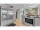 Well-lit kitchen with stainless steel appliances, gray cabinetry, and an open layout to the dining area at 928 W Natal Ave, Mesa, AZ 85210