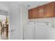 Laundry area with washer, dryer, and wood cabinets, adjacent to the dining area at 928 W Natal Ave, Mesa, AZ 85210