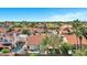 Aerial view of neighborhood featuring beautiful homes with red tile roofs, mature trees, swimming pools, and sunny skies at 10102 E Dreyfus Ave, Scottsdale, AZ 85260