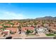 Panoramic aerial view highlighting a neighborhood with mountains in the background and homes with beautiful red tile roofs at 10102 E Dreyfus Ave, Scottsdale, AZ 85260