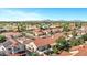 Expansive aerial view of a beautiful suburban neighborhood with lush landscaping, pools, and mountain views at 10102 E Dreyfus Ave, Scottsdale, AZ 85260