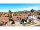 Stunning aerial view of a home with a red tile roof, solar panels, and mountain views in the distance at 10102 E Dreyfus Ave, Scottsdale, AZ 85260