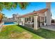 Expansive backyard with a pool, patio area, lush grass, and an orange tree at 10102 E Dreyfus Ave, Scottsdale, AZ 85260