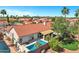 Aerial view of backyard with pool, patio, and red tiled roof house with lush landscaping, ideal for outdoor living at 10102 E Dreyfus Ave, Scottsdale, AZ 85260