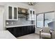 Elegant bar area with herringbone backsplash, open shelving, and black and white cabinetry at 10102 E Dreyfus Ave, Scottsdale, AZ 85260