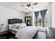 Bright bedroom with large arched window, plush bedding, and ceiling fan at 10102 E Dreyfus Ave, Scottsdale, AZ 85260