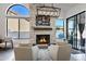 Living room boasts stone fireplace, modern lighting, and a clear view to the outdoors at 10102 E Dreyfus Ave, Scottsdale, AZ 85260