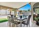 Charming covered patio with a dining table and seating overlooking the pool and green backyard at 10102 E Dreyfus Ave, Scottsdale, AZ 85260