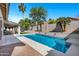 Inviting swimming pool with clear blue water, surrounded by lush greenery and an outdoor patio at 10102 E Dreyfus Ave, Scottsdale, AZ 85260