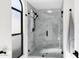 Stylish shower with white marble-patterned tiles, glass enclosure, and black shower hardware at 10102 E Dreyfus Ave, Scottsdale, AZ 85260