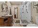 Bathroom with tiled walk-in shower, decorative tile flooring, and wood vanity at 1057 S 74Th St, Mesa, AZ 85208