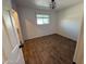 Bedroom features wood-look floors, white walls, ceiling light, and an exterior view window at 1057 S 74Th St, Mesa, AZ 85208