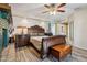 Spacious main bedroom featuring dark wood accents, a ceiling fan, and decorative fireplace at 1057 S 74Th St, Mesa, AZ 85208