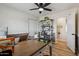 Office features wood-look tile flooring, white walls, a large desk, and a ceiling fan at 1057 S 74Th St, Mesa, AZ 85208