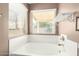 Soaking tub with window, shelf, and neutral walls at 1138 E Avenida Isabela St, Casa Grande, AZ 85122