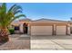Charming single-story home featuring a three-car garage and desert landscaping with a beautiful palm tree at 1138 E Avenida Isabela St, Casa Grande, AZ 85122