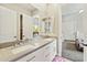 Bright bathroom with double sinks, white cabinetry, and doorway leading to a bedroom at 1160 E Cedar Pl, Chandler, AZ 85249